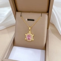 Dettaglio del ciondolo tartaruga dorata con pietra rosa e cristalli su astuccio - Oro-Zirconia Rosa
