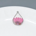 Macro shot of teardrop resin pendant with real pink dried flower and gold foil flakes - Pink Chrysanthemum Teardrop