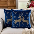 Blue velvet Christmas pillow covers with gold reindeer embroidery on a beige sofa - Embroidered Gold Reindeer Blue Base/Blue