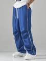 Side view of royal blue wide-leg track pants with double white stripes and drawstring waist - Blue