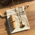 Detail view of 18k gold plated shell pendant necklace and matching ring on linen bag. - Scallop Pendant Necklace 45+5cm