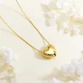 Detail of 18K gold plated heart pendant necklace on a refined textured background - Gold Small 3D Heart
