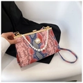 Vue détaillée de la texture peau de serpent et des perles sur ce sac de soirée chic - Rose