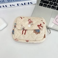 Close-up of quilted floral organizer bag with cartoon bear print on white desk setup - Beige Doll