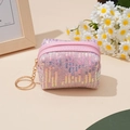 Detalle del monedero de lentejuelas rosas con llavero dorado y fondo floral suave - Rosa