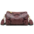 Detailed macro view of vintage floral embossing and golden hardware on the cylinder bag - Deep purple