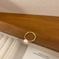 Nahaufnahme eines goldenen Rings mit weißer Perle auf rustikalem Holzuntergrund - Süßwasserperle 18K Gold Offener Ring / Gold