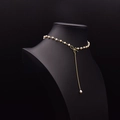 Collier de perles élégant avec pendentif nœud doré et perle pendante sur buste noir - Collier Long en Perles Naturelles