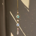 Golden suncatcher with amethyst stones and crystals casting rainbow shadows on wall - Amethyst Circle Style