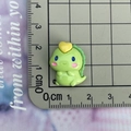 Macro scale shot showing a 2.3cm light green resin dinosaur charm with yellow heart detail - Style 4 / Heart on Head Dinosaur