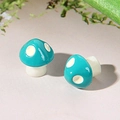 Macro shot of blue resin mushroom earrings with white spots and realistic glossy finish - Blue