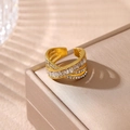 Gros plan d'une bague multicouche dorée avec des diamants rectangulaires et ronds - Style de Design Croisé / Doré
