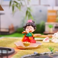 Miniatuur hars meisje in traditionele rode jurk spelend op fluit op een lotus - Fluit spelen