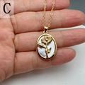 Detail of sunflower pendant necklace with white shell inlay held in hand for close-up view - Style C