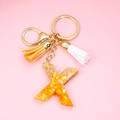 Detail of letter X resin keychain with gold foil flakes and colorful suede tassels - Letter X