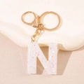 Détail du porte-clés lettre N en résine pailletée avec fermoir mousqueton doré et anneau - Lettre N