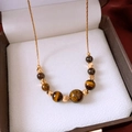 Macro shot of 18k gold-plated chain and tiger eye beads in a luxury jewelry box - Necklace (Real Gold Plated) / Gold/Brown