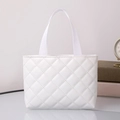 Detail of white quilted PU leather tote bag with woven handles on a minimalist table - Horizontal / Milky White