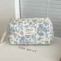 Détail d'une trousse à maquillage matelassée à fleurs bleues avec fermeture éclair et anse - Pochette Octogonale / Pommier Sauvage Bleu