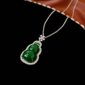 Detailopname van een groene hars kalebas hanger met sprankelende zirkoon op een donker doek - Groene Kalebas Ketting