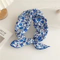 Blue floral printed square silk scarf tied in a bow on a minimalist white desk - Blue Fruit Floral
