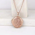 Rose gold round locket necklace with floral engraving on a stone display base - Plum Blossom Round/Rose Gold