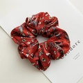 Red satin scrunchie with floral and butterfly prints on a white magazine background - Large Floral Red