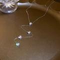 Macro-opname van zilveren Y-ketting met zirkonia druppels op een goudkleurig dienblad - Zilver