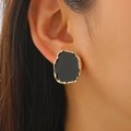 Close-up of irregular black enamel stud earrings with textured gold-plated edges on model - KC Gold Black (06 KC Gold Black 6946)