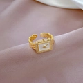 Detail eines goldfarbenen Ringes im Uhrendesign mit Zirkonia auf lila Satin - Einstellbar Offen / Echt Vergoldet Gold