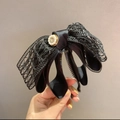 Large black lace bow banana clip with elegant pearl center held by hand - Black Ponytail Clip