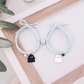 Detail of light blue braided bracelets with magnetic heart clasp and ghost pendants - Light Blue Pair