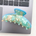 Detail of blue and beige marbled acetate hair claw clip on a silver laptop keyboard - Lake Blue