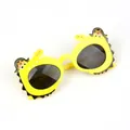 Detail shot of yellow crocodile children sunglasses with pirate hat and black round lenses - Yellow