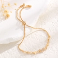 Detail of adjustable gold bracelet featuring butterfly charm and heart accents - Butterfly Heart Style / Gold