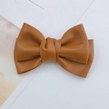 Dettaglio macro del fiocco pieghettato in ecopelle marrone per accessori fai-da-te - Cachi