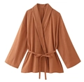 Detail view of caramel wrap top featuring a V-neckline and adjustable waist tie belt - Orange Top