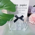 Detailed view of small white organza gift bag with black ribbon and floral background - Black