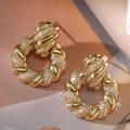 Detailopname van 18K vergulde gedraaide oorringen met sprankelende zirkonia inleg - Gedraaide Ring / Goud