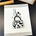 Dettaglio portachiavi mini borsa in peluche leopardato con moschettone d'argento e pompon - Bianco