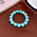 Macro detail of turquoise beaded bracelet with natural textures on brown fabric - 12mm / Blue