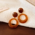 Boucles d'oreilles créoles en résine ambre géométrique sur un pull en maille blanc - 47# Pendentif Ambre Boule Marron (Tige en Argent)
