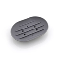 Detail view of grey silicone soap holder showing five drainage slots and nonslip texture - Oval / Gray