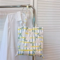 Close-up of floral pattern canvas tote bag hanging with white shirt in casual setting - Yellow Blue Striped Flowers