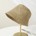 Detail of khaki PU leather bucket hat with precise double stitching on a metal stand - Khaki