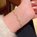 Elegant gold bracelet featuring zircon flowers and opal butterfly charms on wrist - S744 Gold