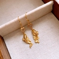 Macro shot of gold koi fish earrings with auspicious cloud hooks on beige linen tray - Gold Auspicious Cloud Koi Hook Style