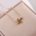 Dettaglio della collana a croce dorata con intarsio magenta scintillante su astuccio - Viola