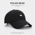 Classic black cotton baseball cap featuring small white polar bear embroidery and curved brim - Black