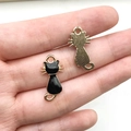 Dettaglio di ciondoli a forma di gatto in smalto nero e retro in metallo dorato - Schiena di Gatto Nero